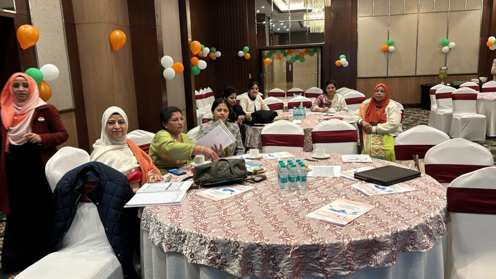 Members of the Aligarh Obstetrics & Gynaecological Society (AOGS) gathered at a conference venue during a scientific meeting, with event materials, refreshments, and Indian tricolor decorations promoting professional collaboration and women's healthcare.